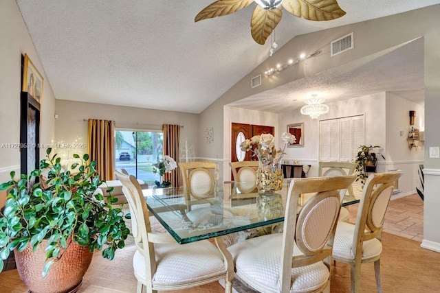 dining room with ceiling fan, a textured ceiling, and lofted ceiling