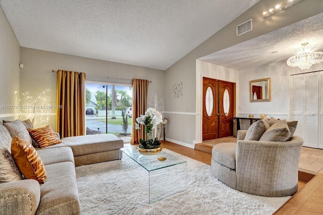 living room with vaulted ceiling, an inviting chandelier, and a textured ceiling