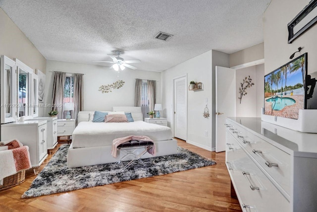 bedroom featuring ceiling fan, a textured ceiling, and wood-type flooring