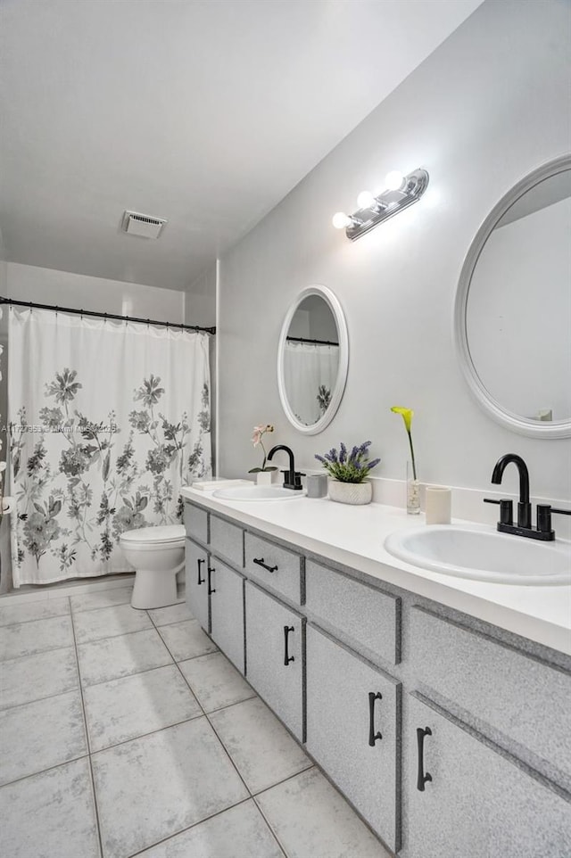 bathroom with toilet, tile patterned floors, and vanity