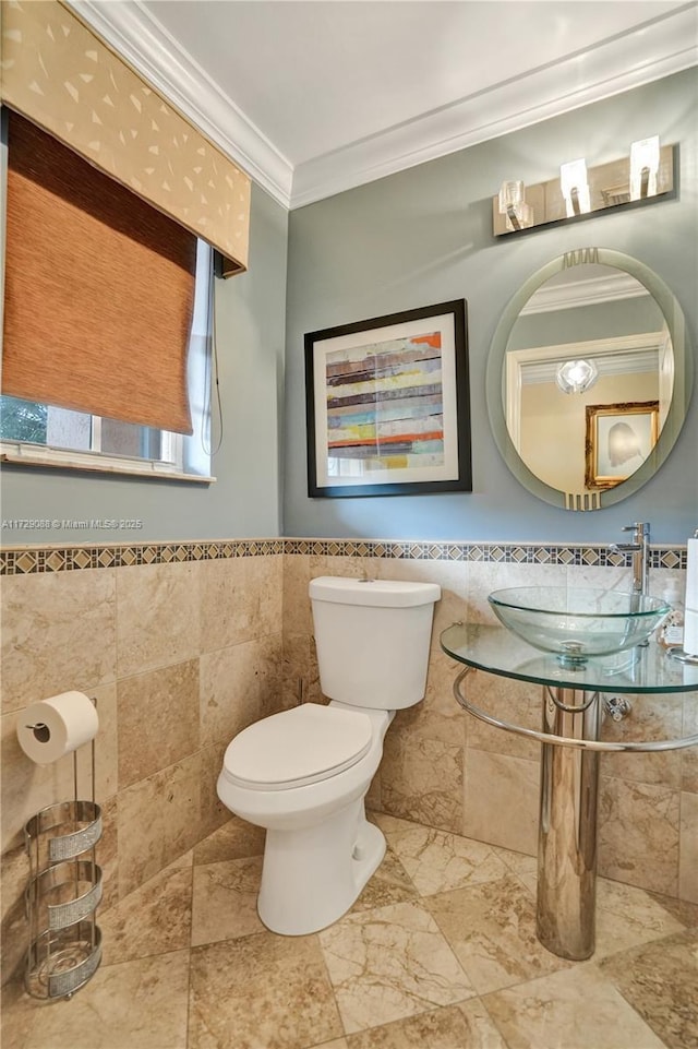 bathroom featuring toilet, tile walls, sink, and crown molding