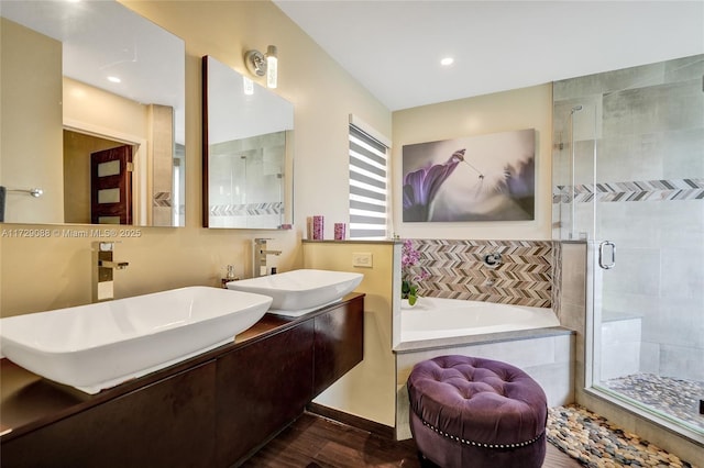 bathroom featuring shower with separate bathtub and vanity