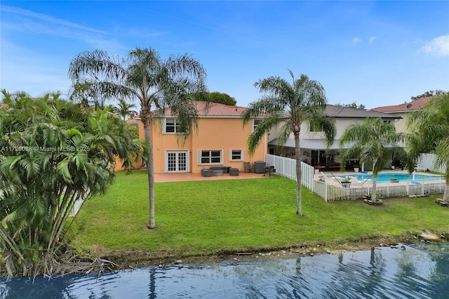 back of house featuring a patio area, central air condition unit, a water view, and a yard