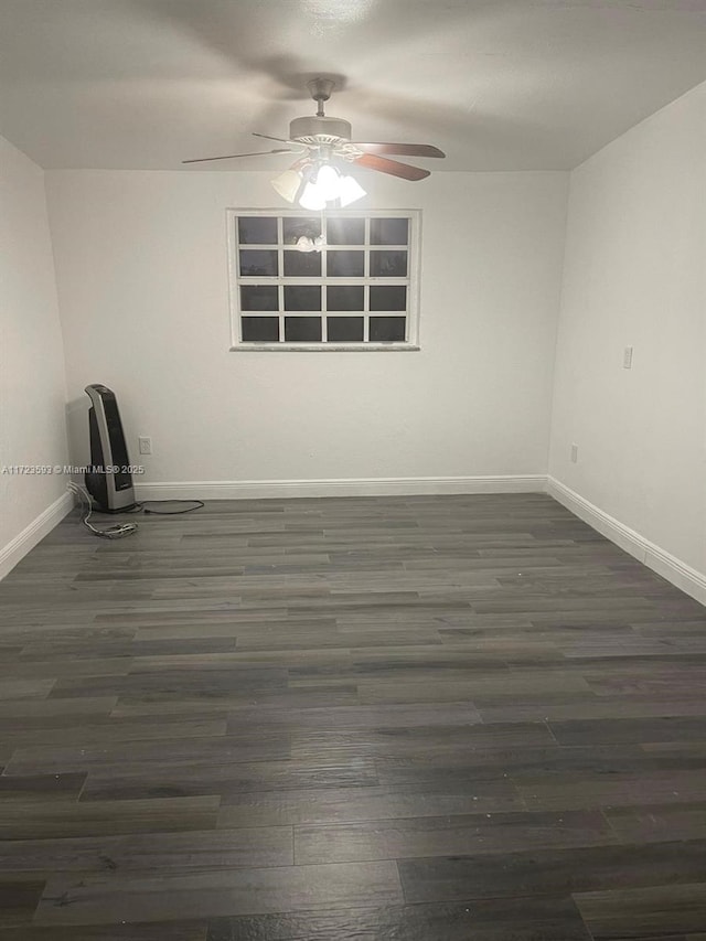 spare room featuring dark wood-type flooring and ceiling fan