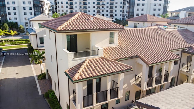 rear view of property with stucco siding and a tiled roof