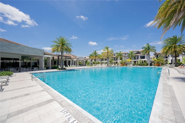 community pool with a patio area and a residential view