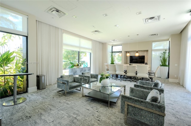 living area featuring carpet floors, visible vents, and a healthy amount of sunlight