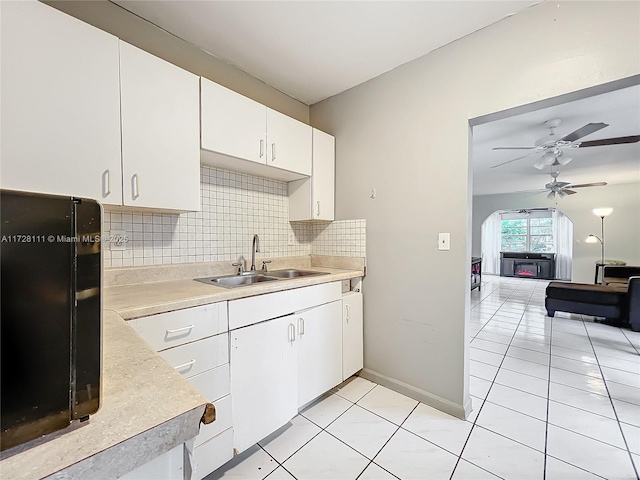 kitchen with light tile patterned flooring, white cabinetry, sink, backsplash, and ceiling fan