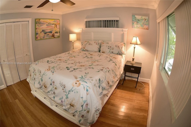 bedroom with hardwood / wood-style floors, a closet, ceiling fan, and ornamental molding