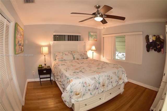 bedroom with ceiling fan, dark hardwood / wood-style flooring, a closet, and crown molding