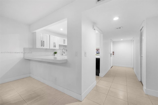 hallway with sink and light tile patterned floors