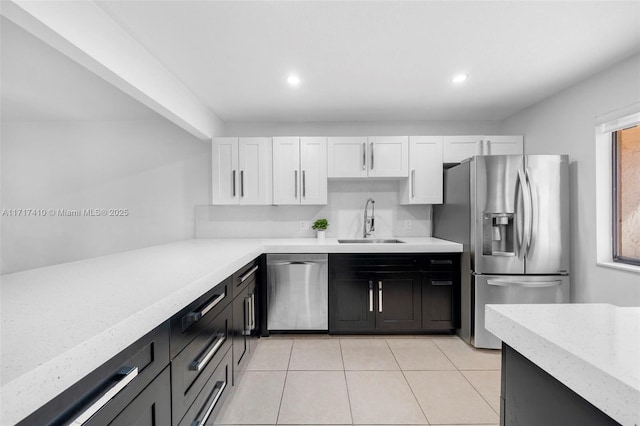 kitchen with a wealth of natural light, stainless steel appliances, white cabinetry, and sink