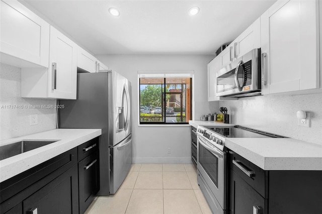 kitchen featuring backsplash, white cabinetry, and stainless steel appliances