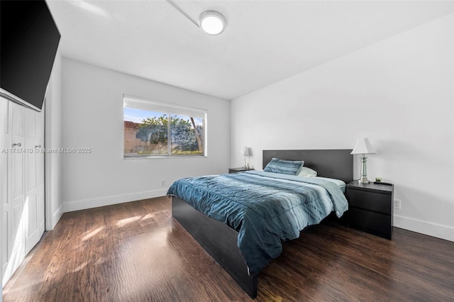 bedroom with dark hardwood / wood-style flooring and a closet