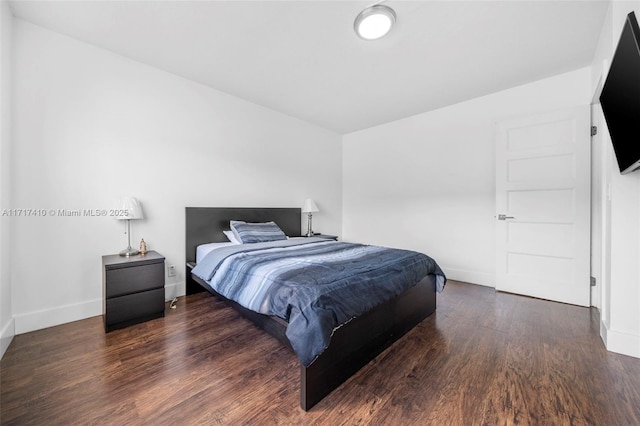 bedroom with dark hardwood / wood-style floors