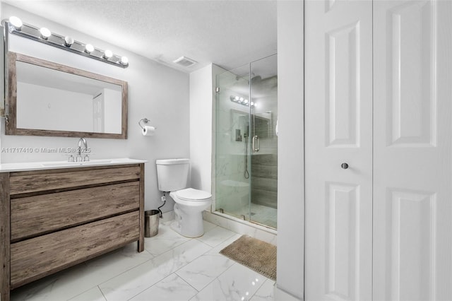 bathroom featuring a textured ceiling, toilet, a shower with shower door, and vanity