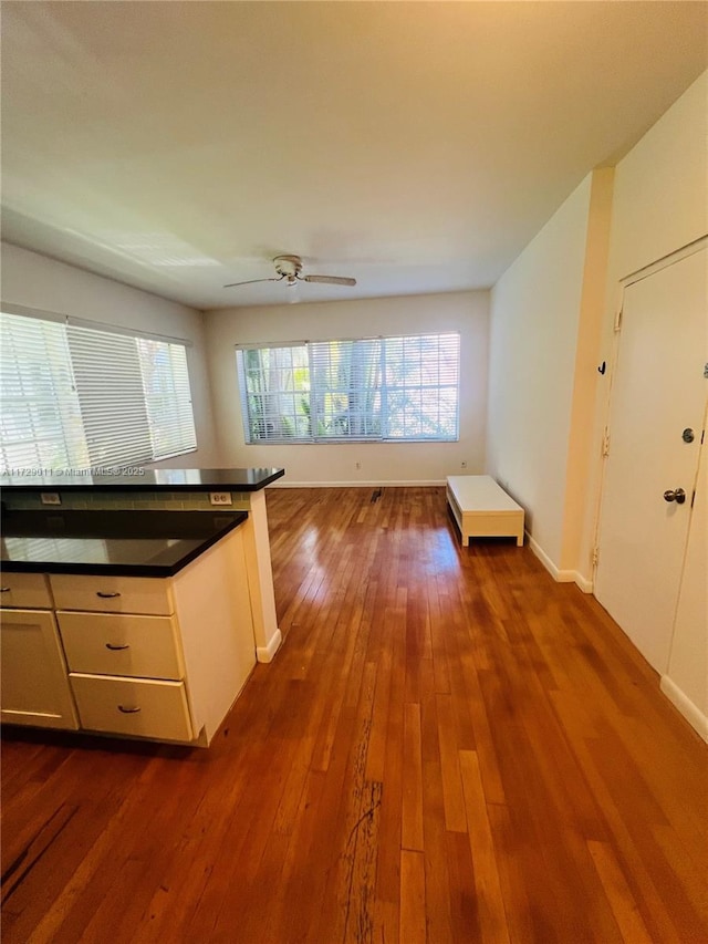 1523 W Ave Unit 101, Miami Beach, FL 33139 - kitchen featuring dark wood-style floors, healthy amount of natural light, dark countertops, and baseboards