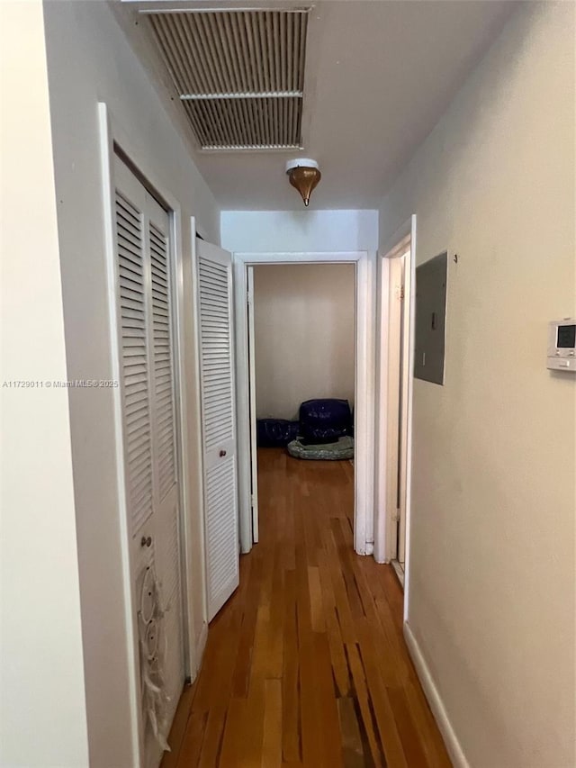 hall featuring electric panel and hardwood / wood-style flooring