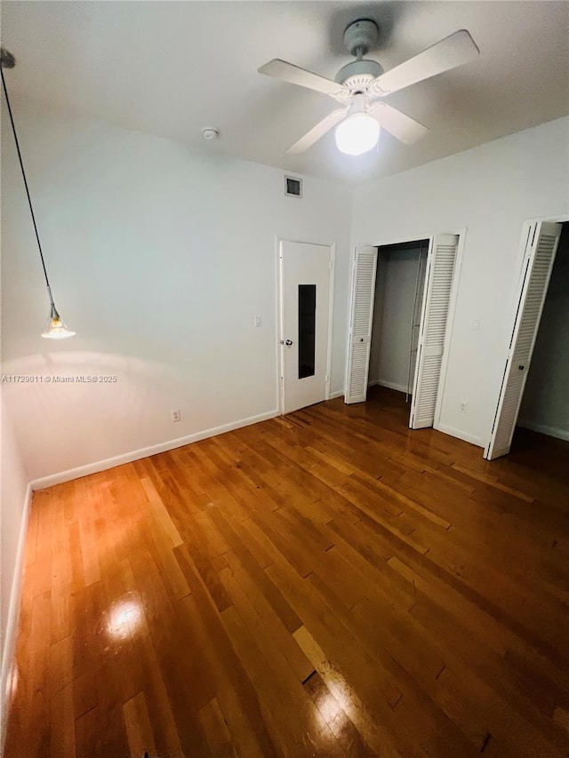 1523 W Ave Unit 101, Miami Beach, FL 33139 - unfurnished bedroom with hardwood / wood-style floors, multiple closets, baseboards, and a ceiling fan