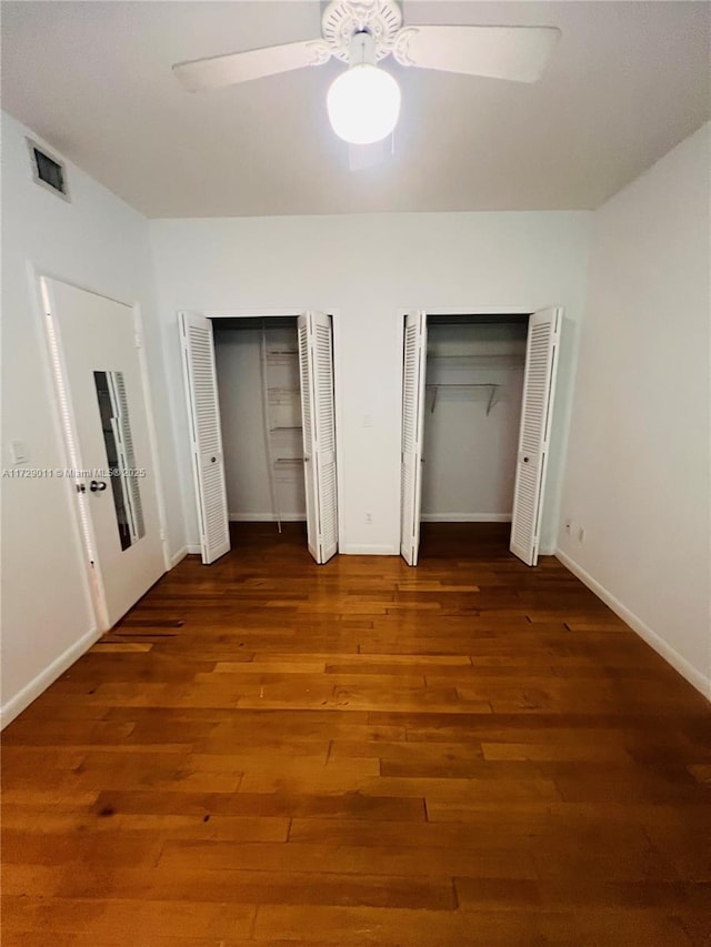 1523 W Ave Unit 101, Miami Beach, FL 33139 - unfurnished bedroom with two closets, wood finished floors, baseboards, and a ceiling fan