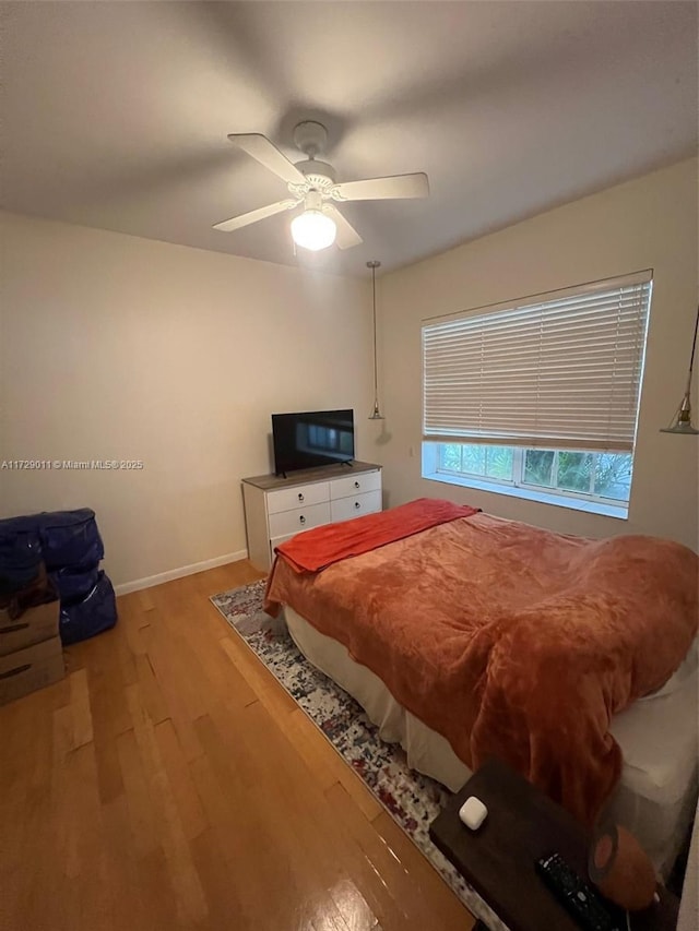 bedroom with ceiling fan and light hardwood / wood-style flooring