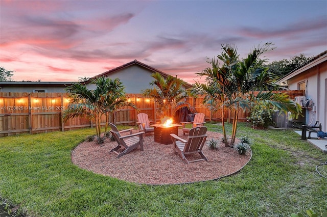 yard at dusk featuring an outdoor fire pit and central air condition unit