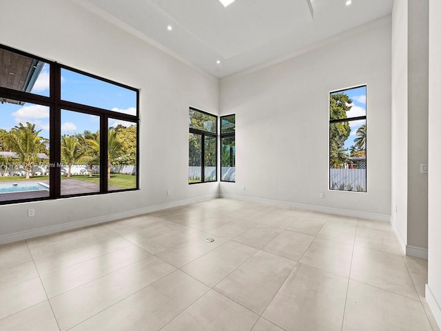 tiled spare room with a towering ceiling