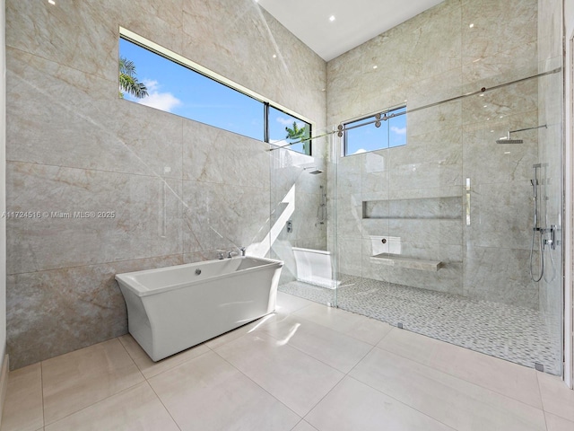 bathroom featuring tile patterned flooring, tile walls, and separate shower and tub