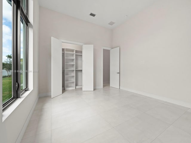 unfurnished bedroom featuring light tile patterned floors and a closet