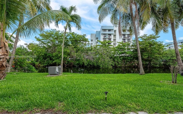 view of yard featuring central AC and a water view