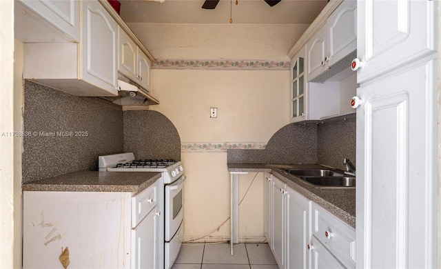 kitchen with sink, white cabinetry, light tile patterned flooring, white range with gas cooktop, and decorative backsplash