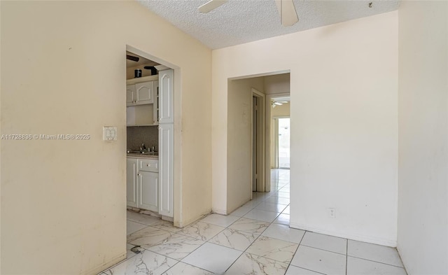 corridor with sink and a textured ceiling