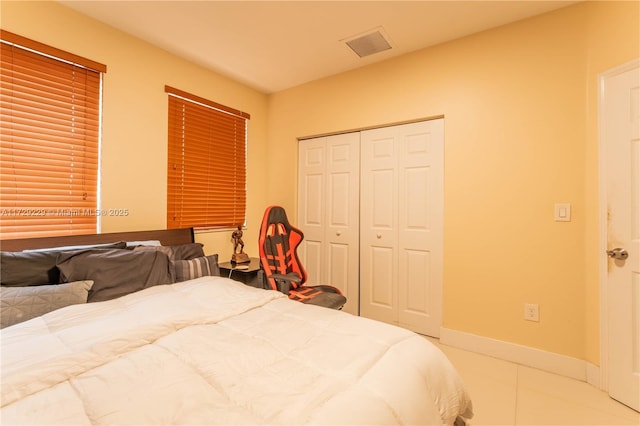 bedroom with light tile patterned floors and a closet