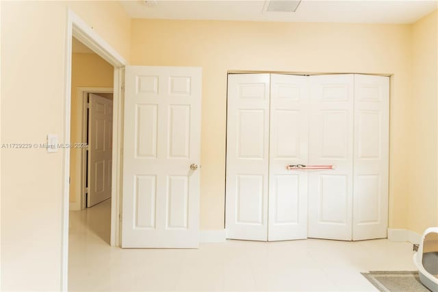 unfurnished bedroom with light tile patterned floors and a closet