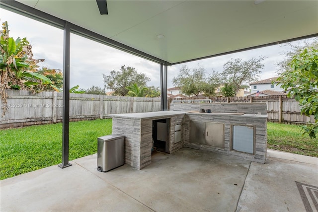 view of patio featuring ceiling fan and an outdoor kitchen