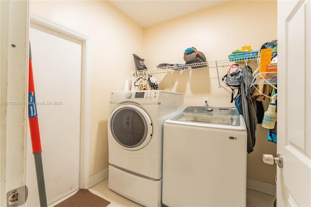 laundry area featuring light tile patterned floors and washing machine and dryer