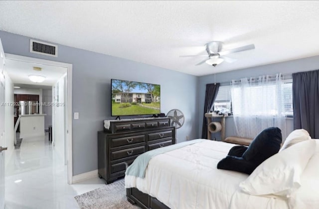 bedroom with ceiling fan and a textured ceiling