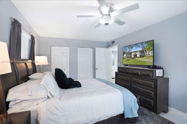 bedroom featuring ceiling fan and multiple closets