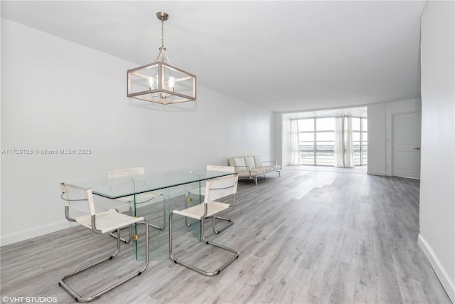 unfurnished dining area featuring an inviting chandelier, floor to ceiling windows, and light hardwood / wood-style flooring