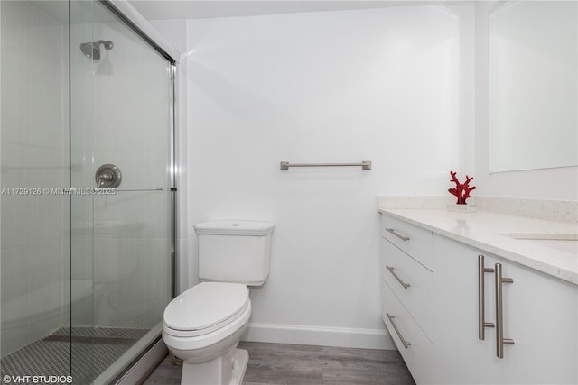 bathroom featuring hardwood / wood-style flooring, toilet, vanity, and an enclosed shower