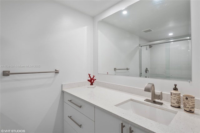 bathroom featuring an enclosed shower and vanity