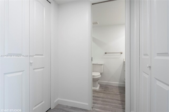 bathroom with hardwood / wood-style flooring and toilet