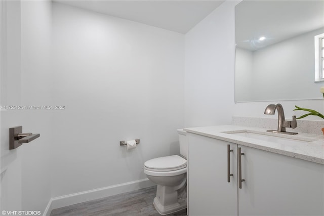 bathroom featuring hardwood / wood-style floors, toilet, and vanity