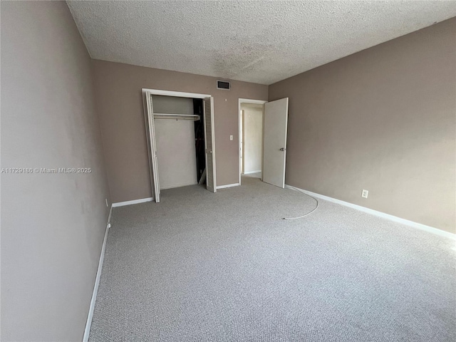 unfurnished bedroom with carpet floors, a closet, and a textured ceiling