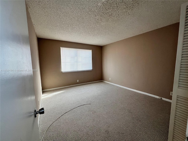 carpeted spare room featuring a textured ceiling