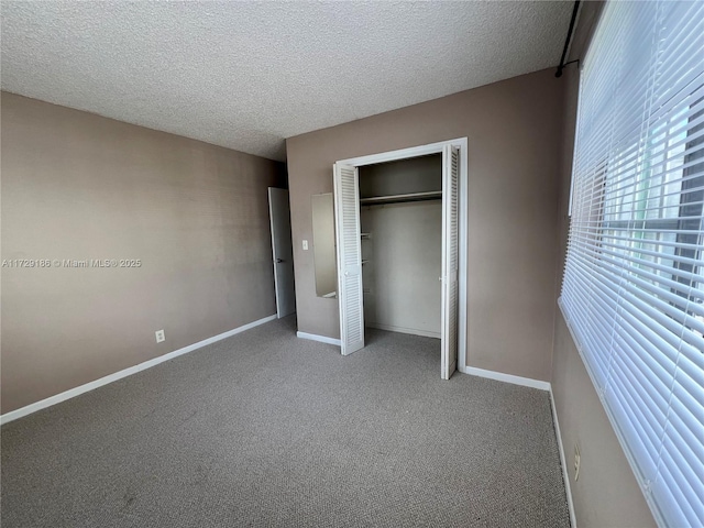 unfurnished bedroom featuring a textured ceiling, a closet, and carpet floors