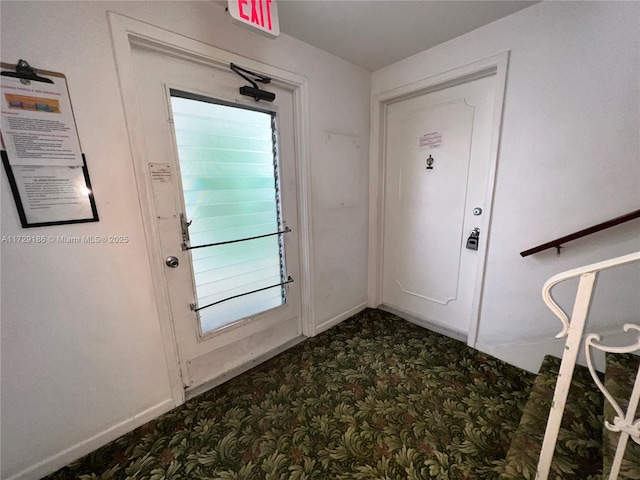 doorway to outside featuring dark colored carpet