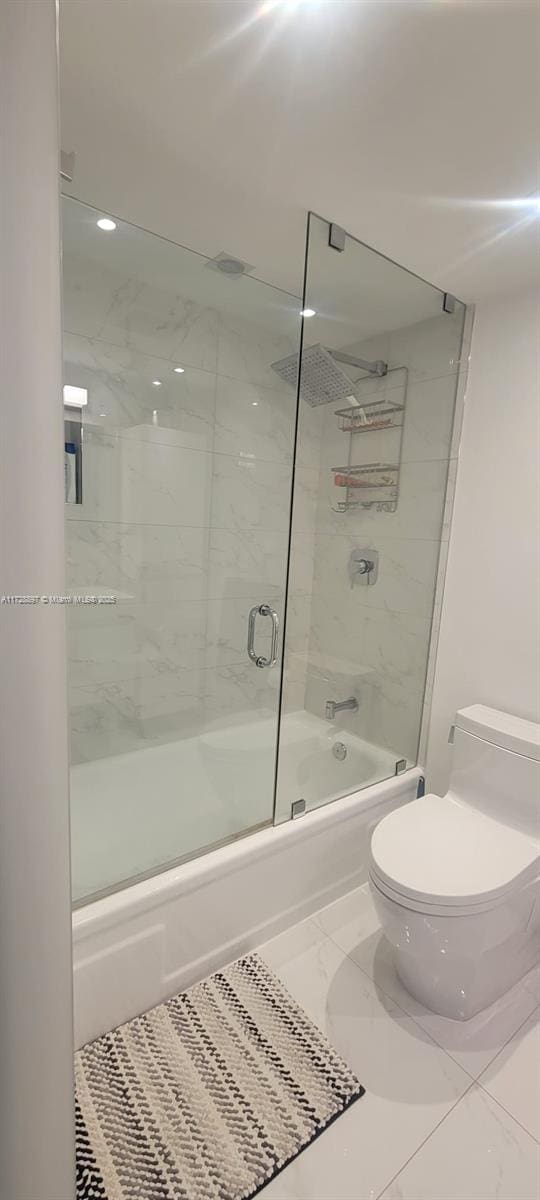 bathroom with toilet, enclosed tub / shower combo, and tile patterned flooring