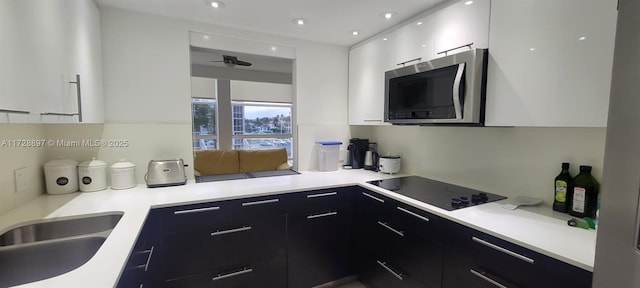 kitchen with sink, white cabinets, and black electric stovetop