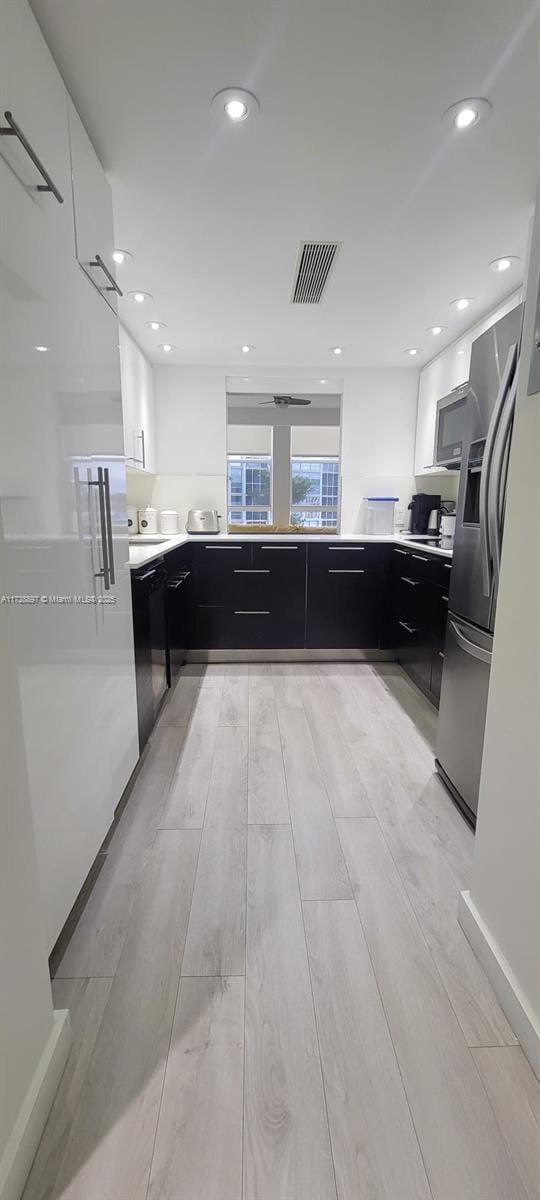 kitchen with dishwasher, stainless steel fridge, white cabinetry, and light hardwood / wood-style flooring